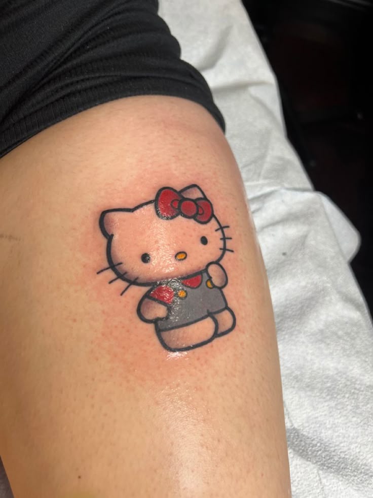 A Woman S Thigh With A Hello Kitty Tattoo On Her Left Leg And An Arrow A Woman S Thigh With A Hello Kitty Tattoo On Her Left Leg And An Arrow